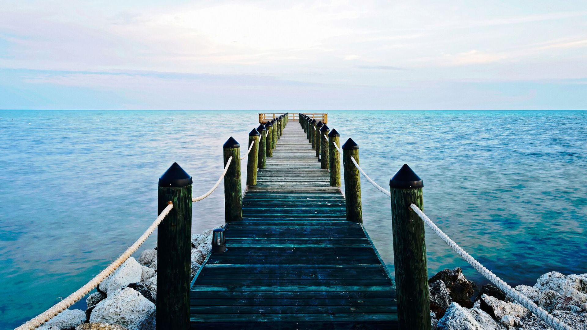 A Wooden Pier Next To A Body Of Water
